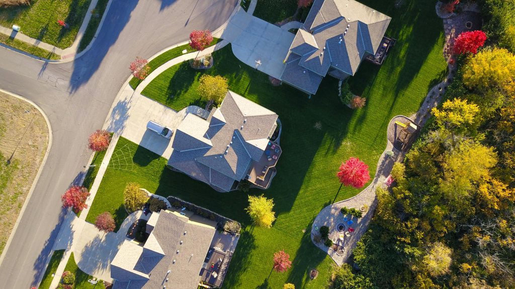 A picturesque aerial view showcasing suburban homes with vibrant gardens and tree-lined streets.